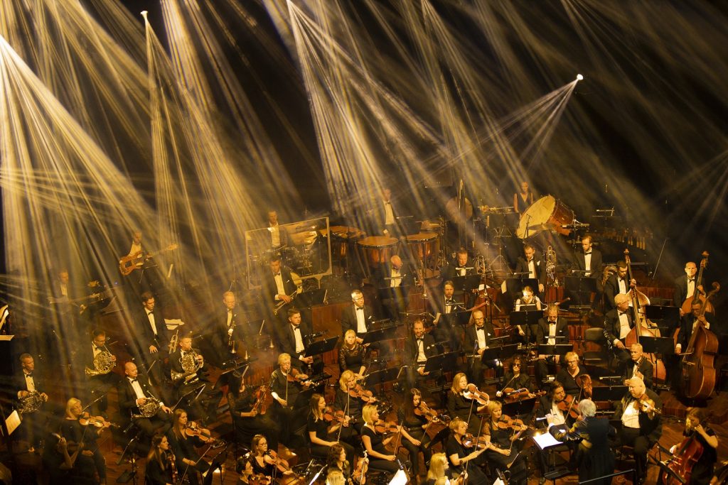 Liepājas Simfoniskā orķestra mūziķi uz izgaismotas skatuves