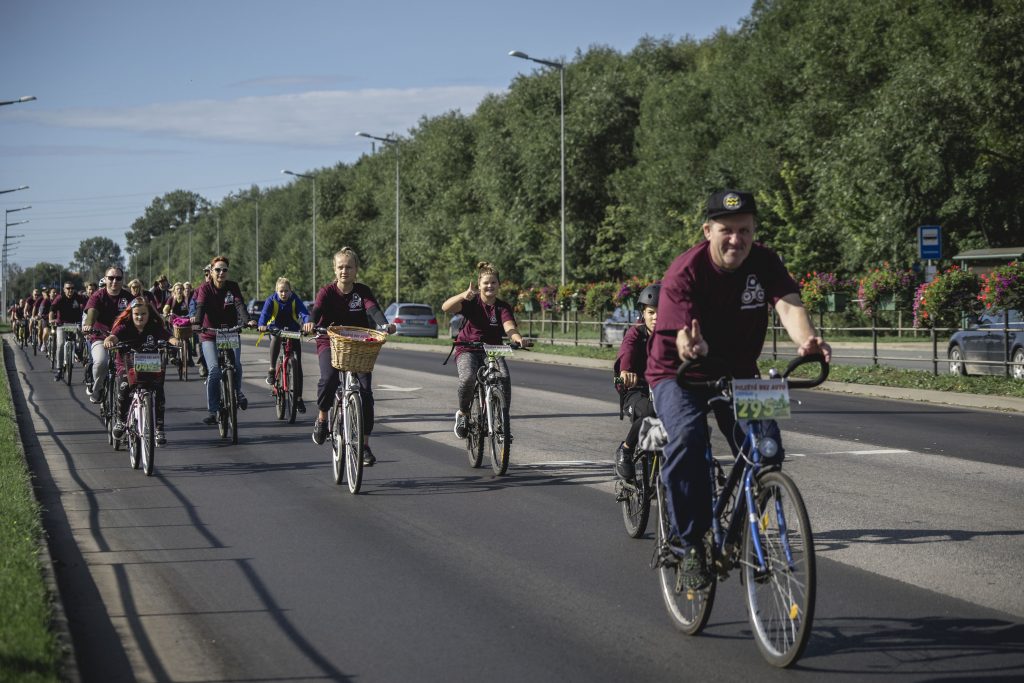 Riteņbraucēji brauc pa šoseju