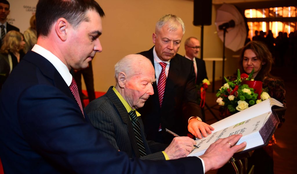 Goda liepājnieks Modris Zihmanis parakstās goda grāmatā.