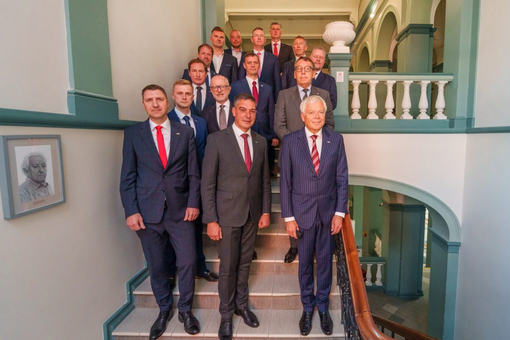 15 kungi tumšos uzvalkos sapulcējušies uz kopbildi