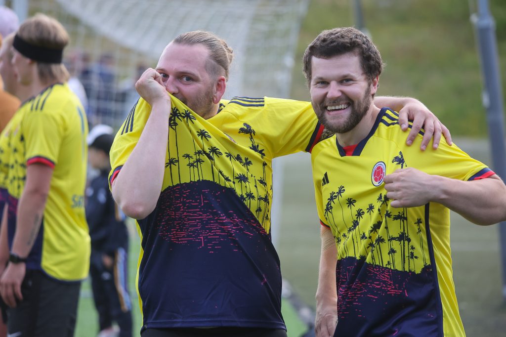 Divi futbolisti dzeltenos kreklos priecīgi par uzvaru