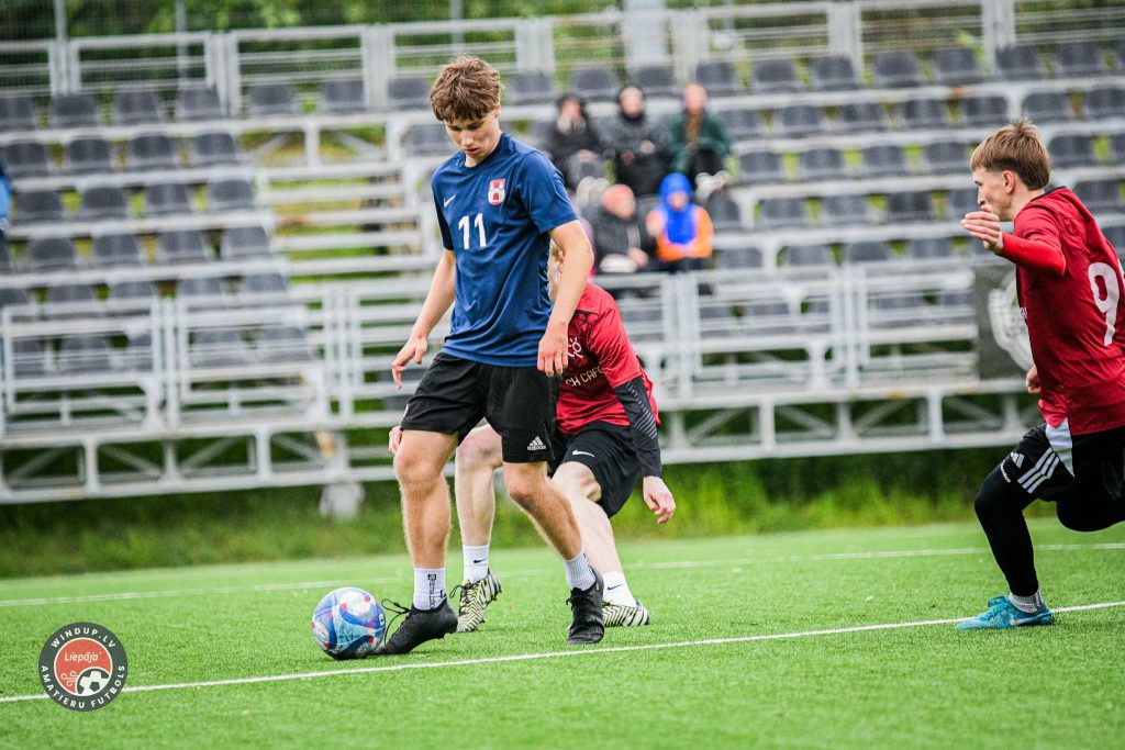 Norisinās futbola spēke. Divi futbolisti uz laukuma cīnās par bumbu