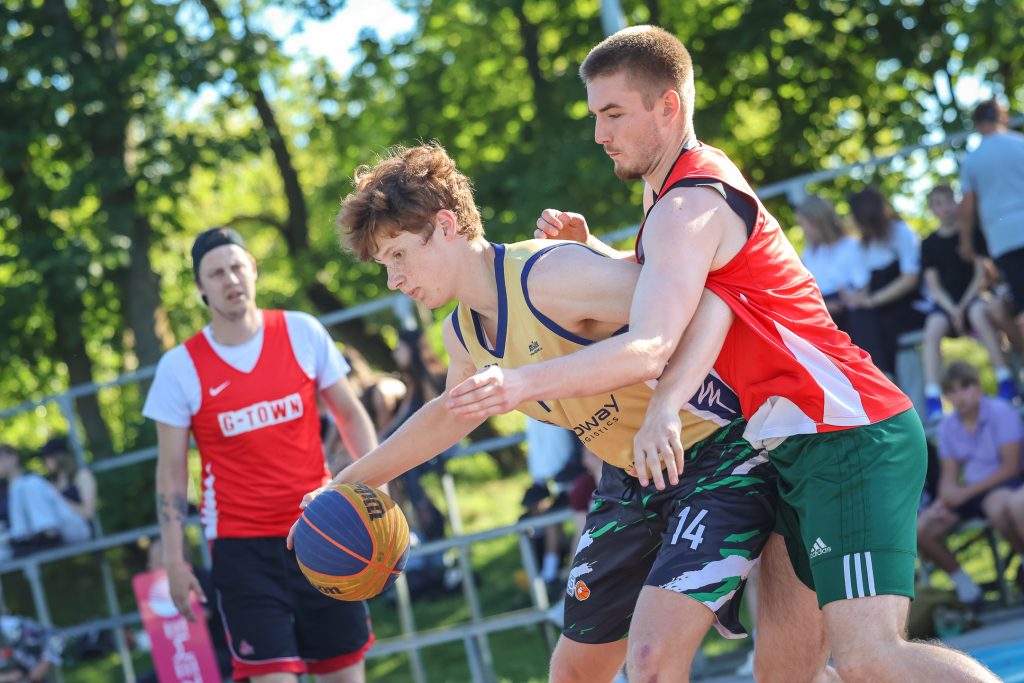 Bruģa bumbas dalībnieki spēlē basketbolu. Divu komandu spēlētāji cīnās par bumbu